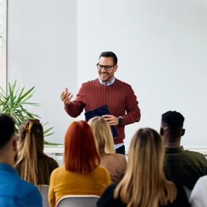 A man speaking to an audience in a classroom setting