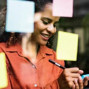 Images of a women writing a note on a sticky note