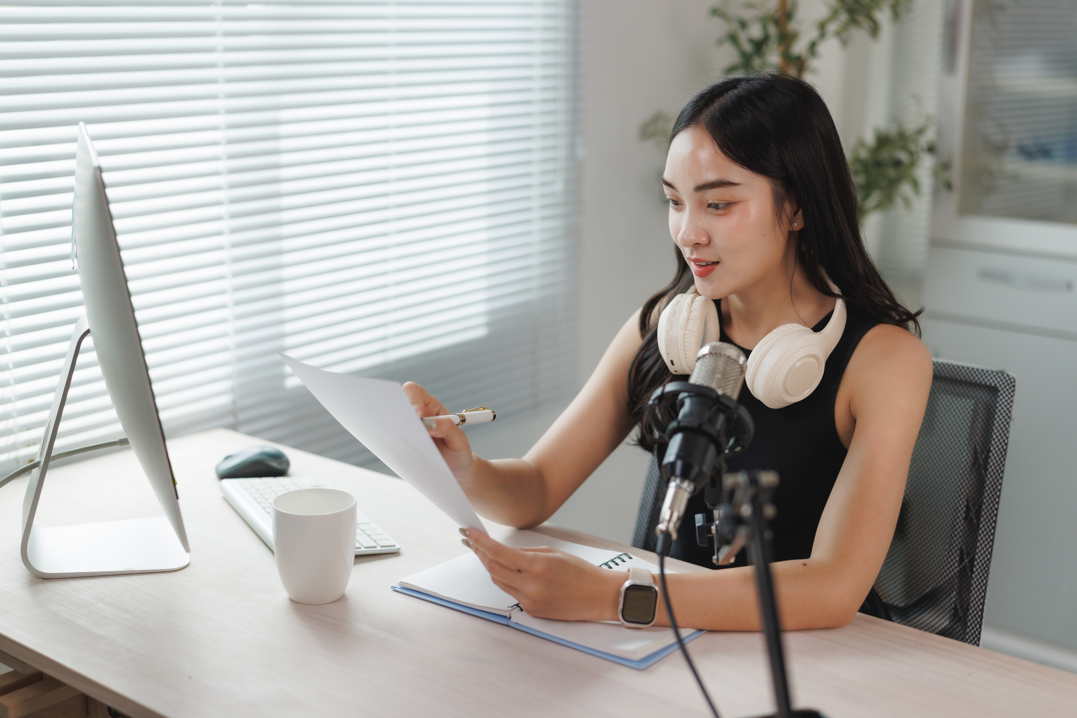 Young asian woman recording a podcast in a home studio,